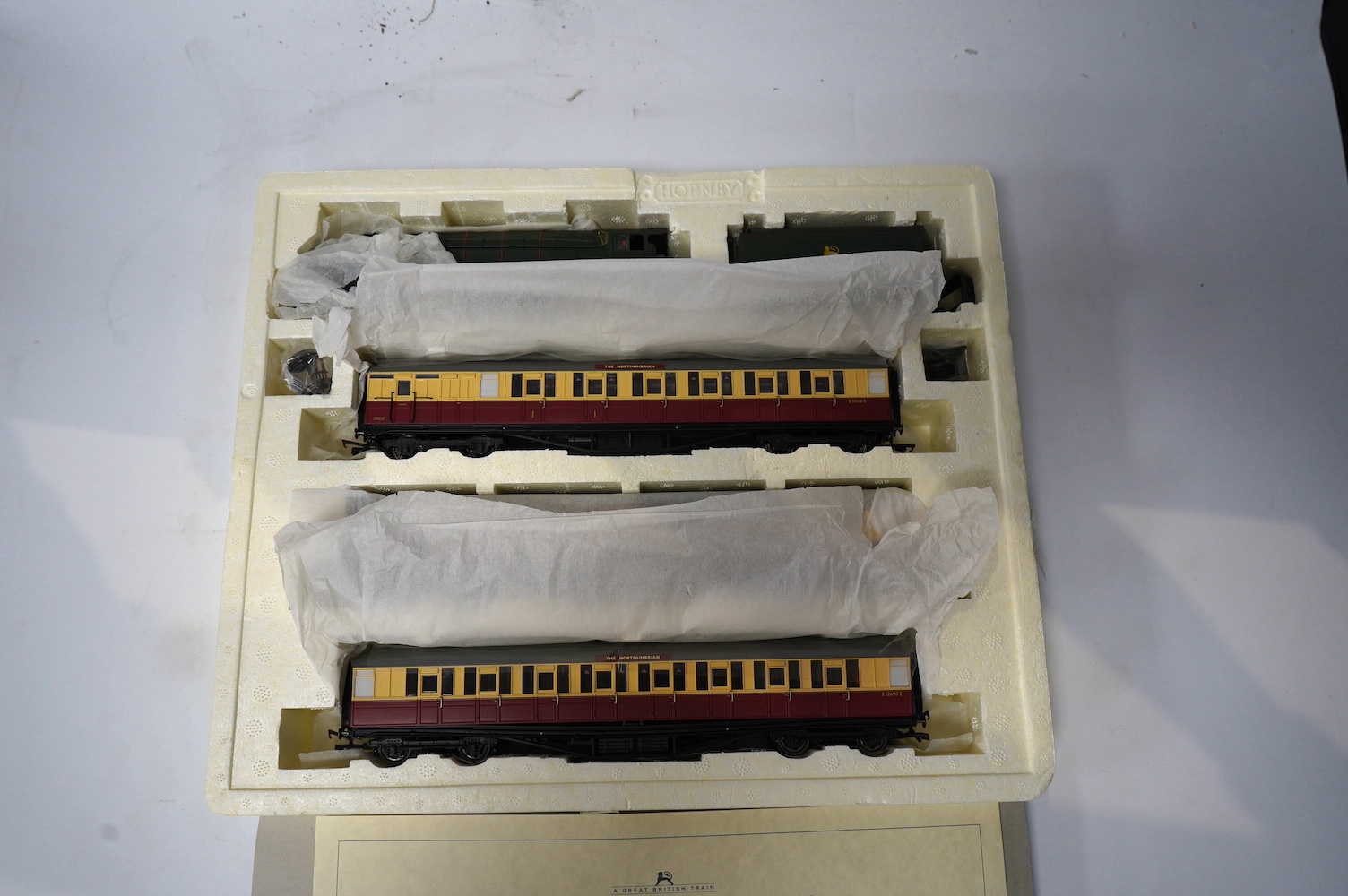 A Hornby Hobbies 00 gauge railway ‘the Northumbrian’ train pack, R2435, together with ‘the Northumbrian Coaches’ coach pack, R4228, comprising of a BR Class A4 locomotive and six maroon and cream coaches. Condition - goo